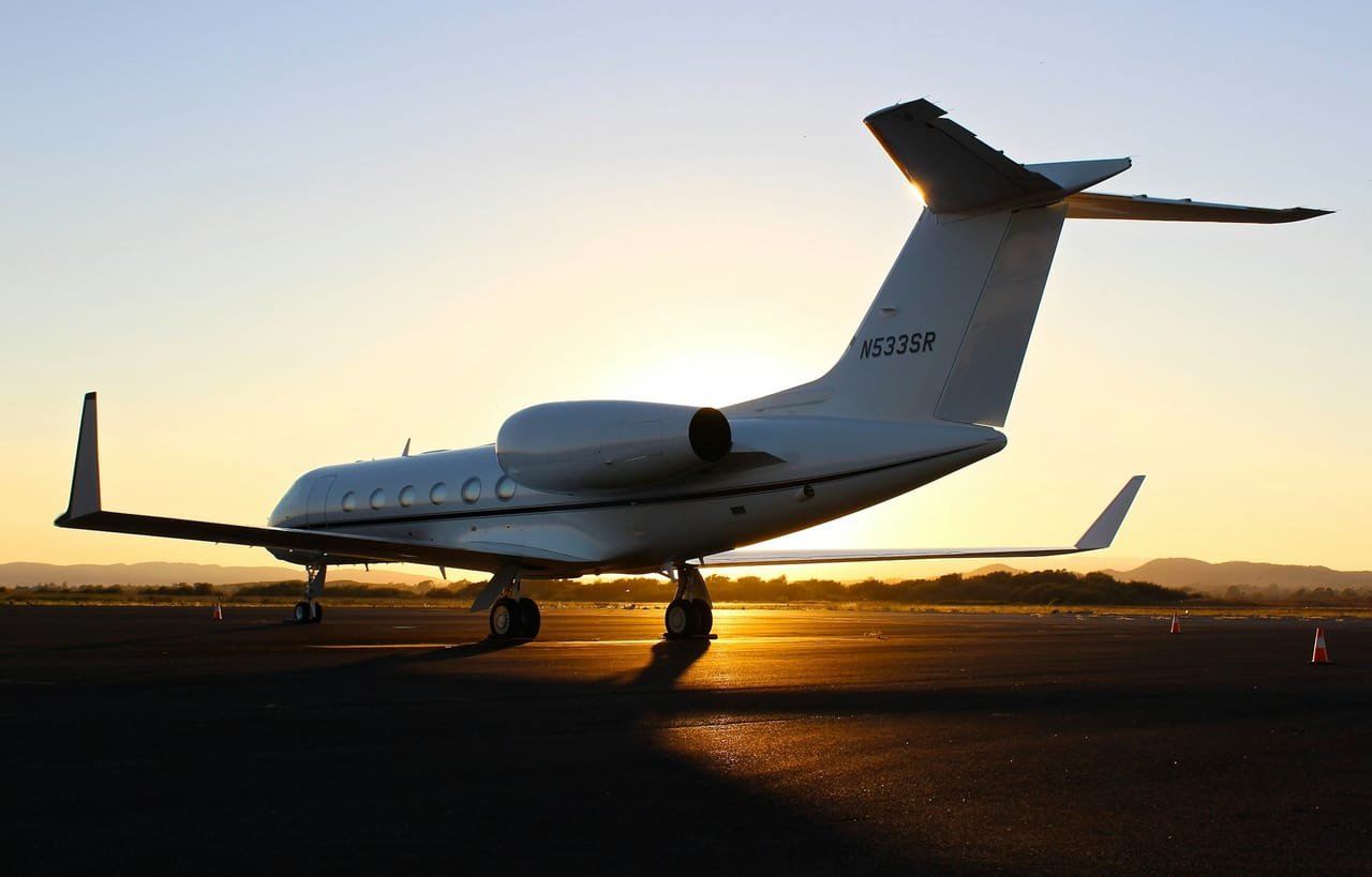 Private jet silhouetted on the apron at sunset